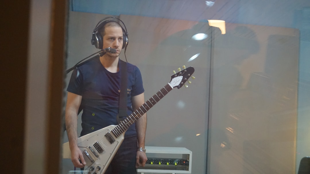 A man with headphones and a guitar
