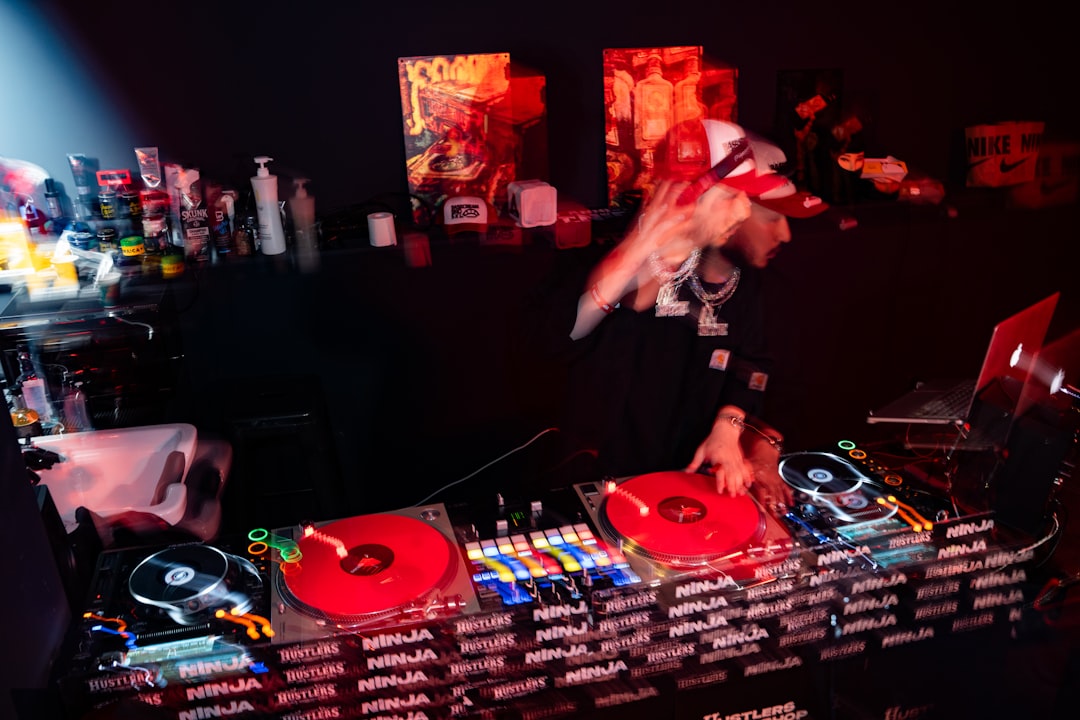 Dj performing with turntables and mixer at night