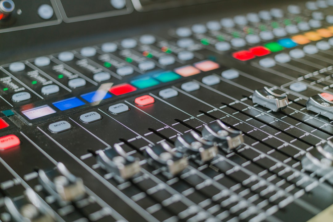 Close-up of a professional audio mixing console with sliders.