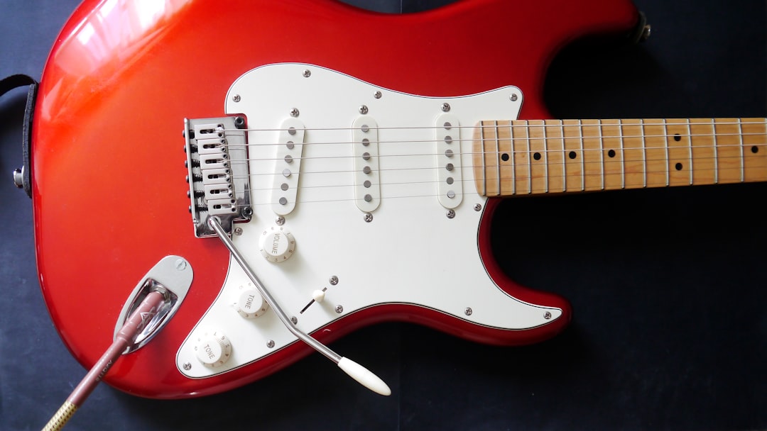 A red electric guitar with a white pick up