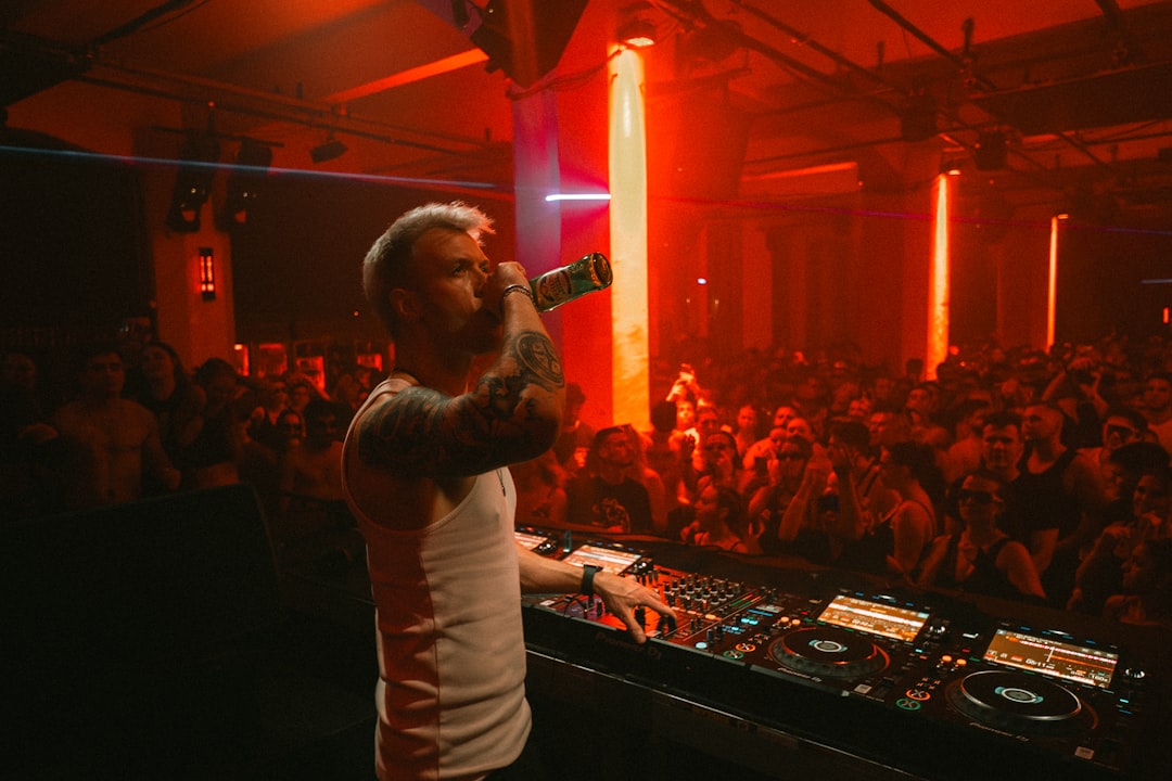 Dj performing for a crowd with red lights