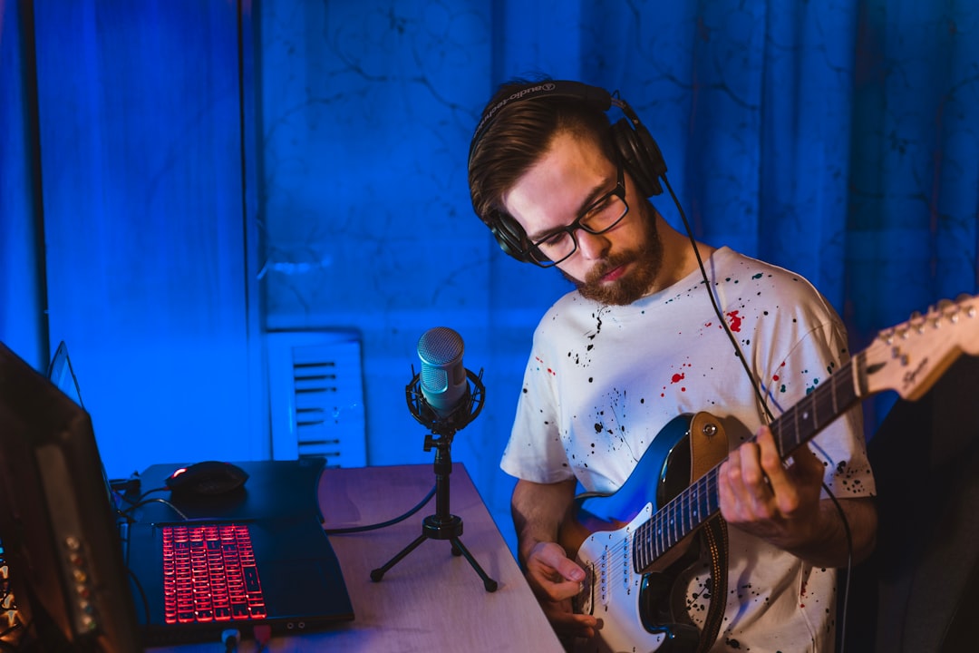 Man in white crew neck t-shirt playing electric guitar