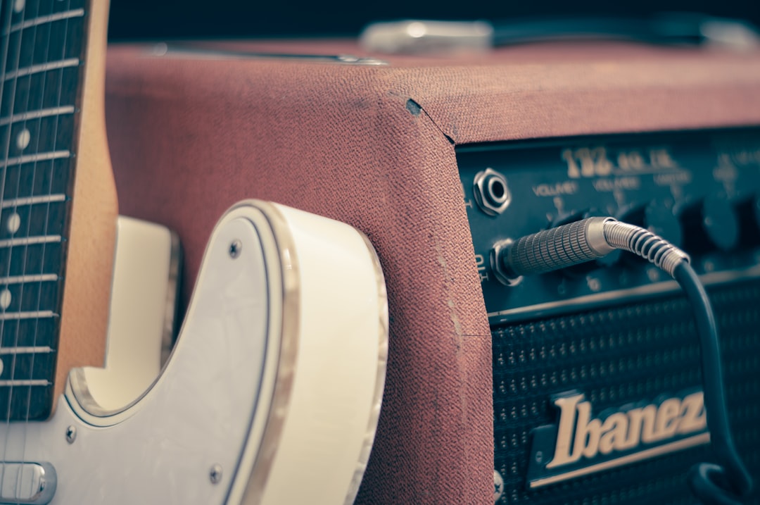 White electric guitar leaning on Ibanez amplifier