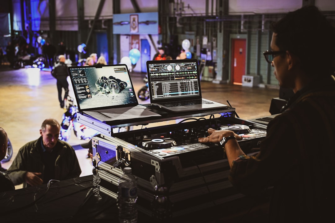 Dj performing with laptops and equipment at event
