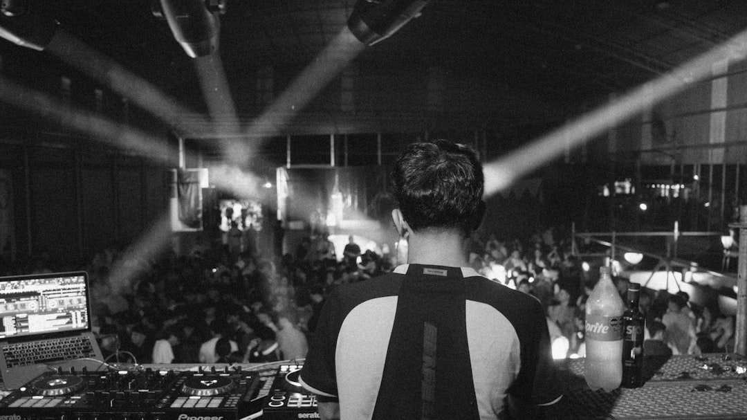 Dj performing for a crowd with stage lights