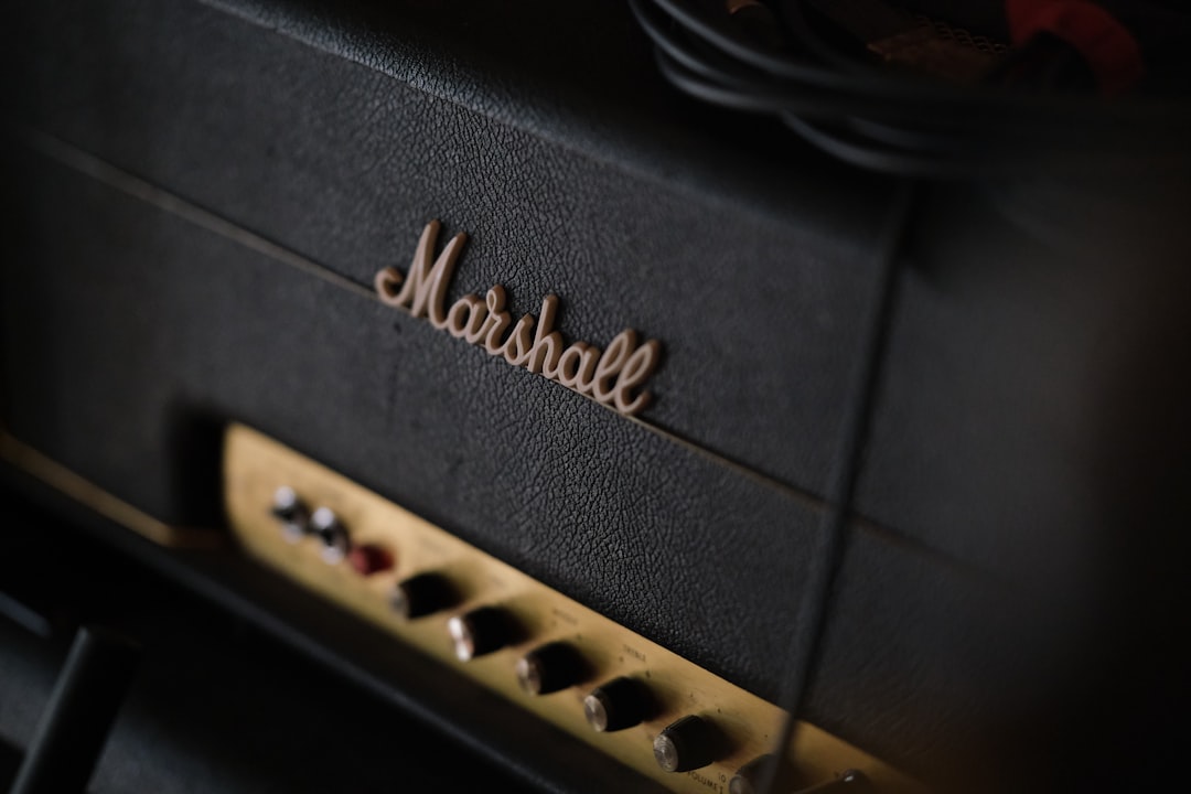 A black marshall guitar amplifier with gold control knobs.