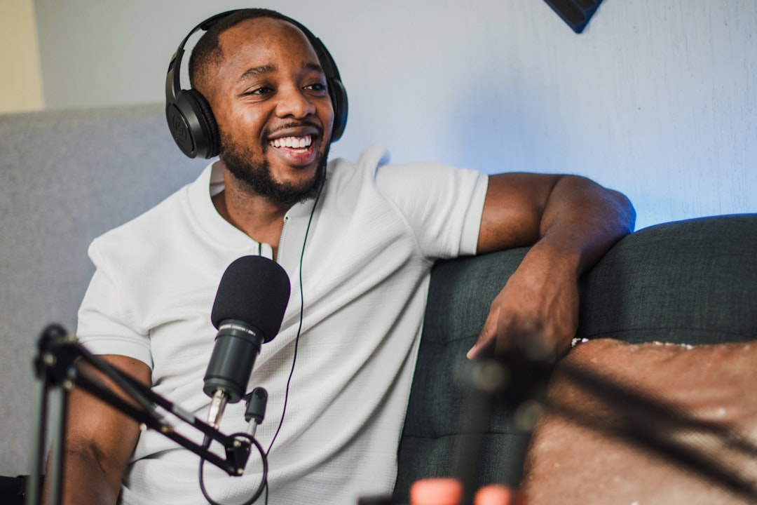 A man wearing headphones sitting in front of a microphone