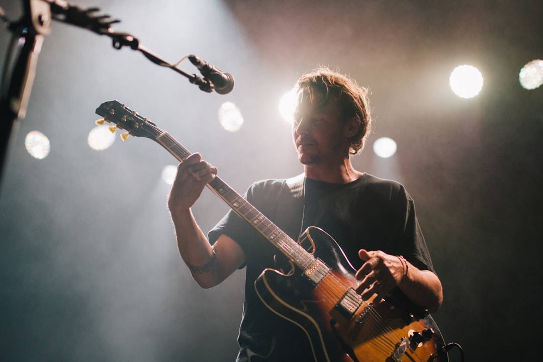 Man playing guitar under spotlight