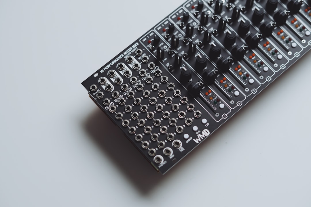 A black electronic audio mixer with many knobs