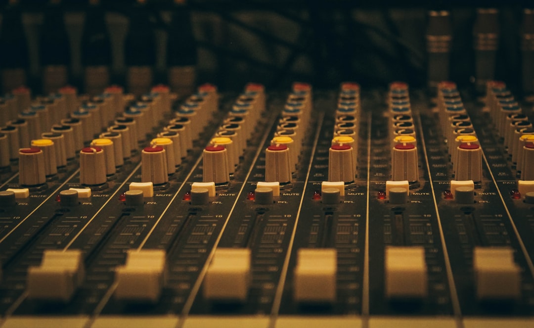 A close up of a sound board with many knobs