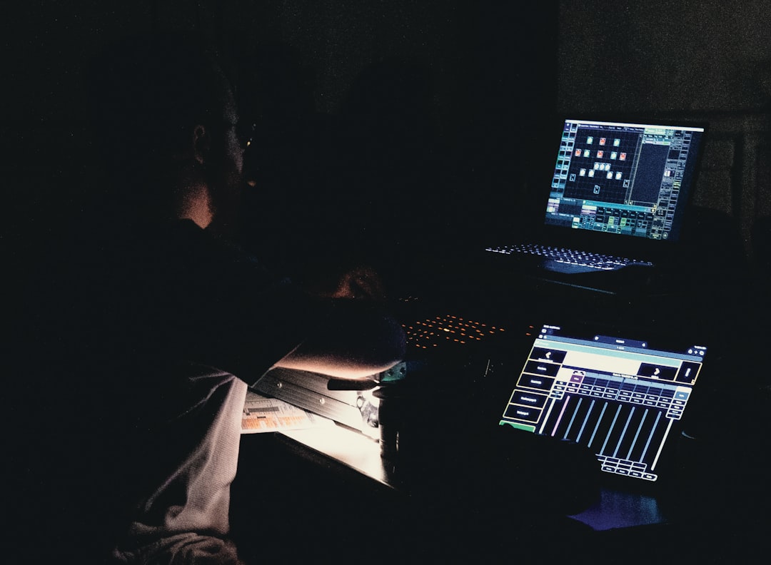 Person working on computer and audio equipment