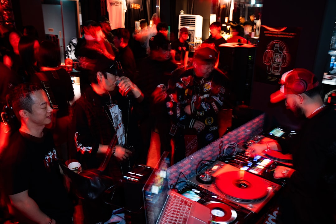 People gathered around a dj booth at a club.