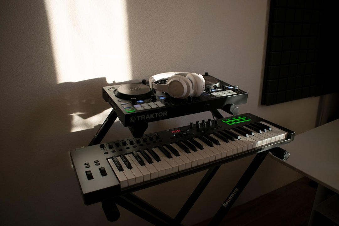 Dj controller with headphones and midi keyboard on stands.