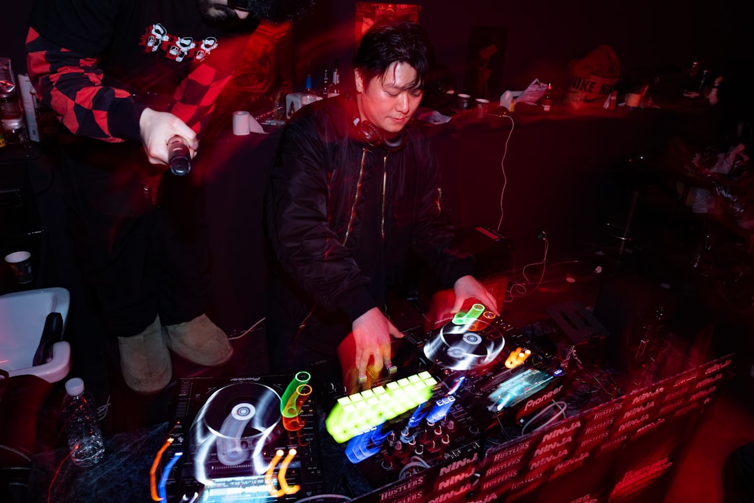 Dj performing at a nightclub with colorful lights