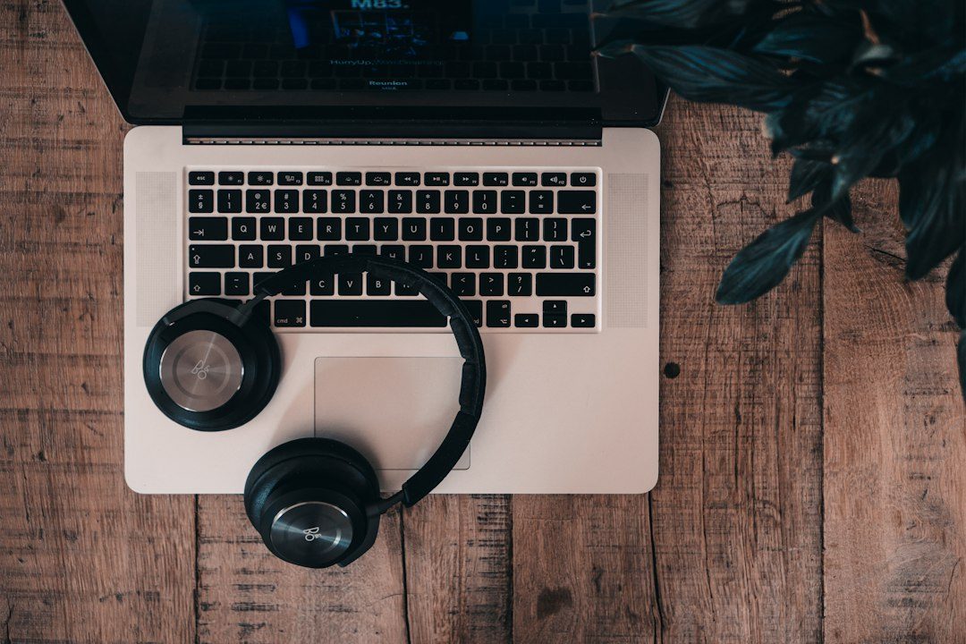 Headphones resting on a laptop, ready for AI music production